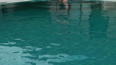 Güzel mutlu genç kadın gülümseyerek ve Otel havuzunda rahatlatıcı güneş gözlüğü