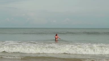 Bir deniz dalgaları ile bikinili genç kadınlarda sahiptir güneşlenme ve plaj tatil