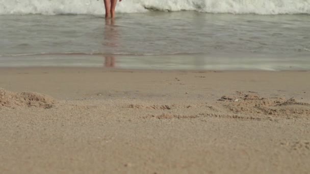 Las mujeres despreocupadas en un bikini sale del mar con olas disfruta tomando el sol y vacaciones en la playa — Vídeos de Stock