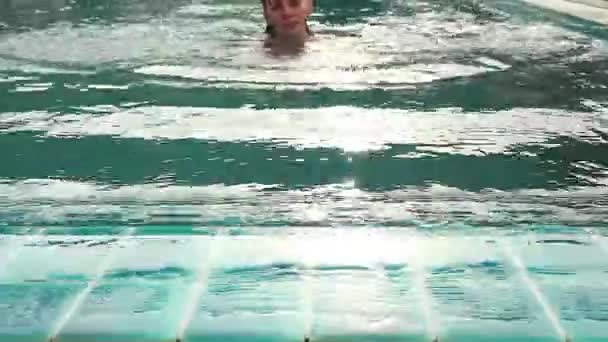 Jovem relaxante e lentamente nada na piscina — Vídeo de Stock