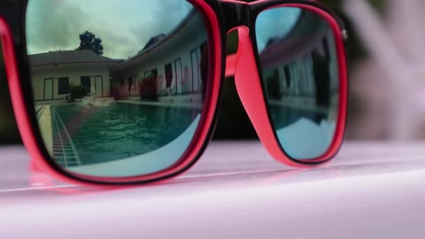 Две девочки-подростка играют, плавают и наслаждаются заплывами в бассейне во дворе. отражение в солнечных очках — стоковое видео