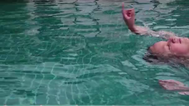 Linda chica adolescente jugando riendo nadando en hoteles piscina divirtiéndose — Vídeo de stock