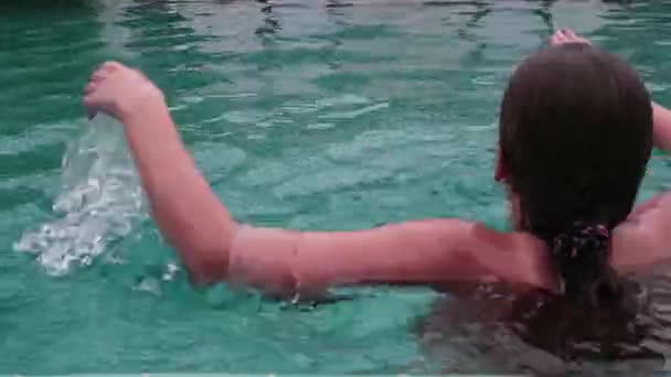 Linda chica adolescente jugando riendo nadando en hoteles piscina divirtiéndose — Vídeos de Stock