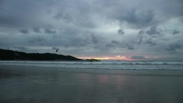 A naplemente Seascape tükröződik nedves tengerparti homokot bejövő hullámok. motoros csónak, siklórepülés a láthatáron — Stock videók