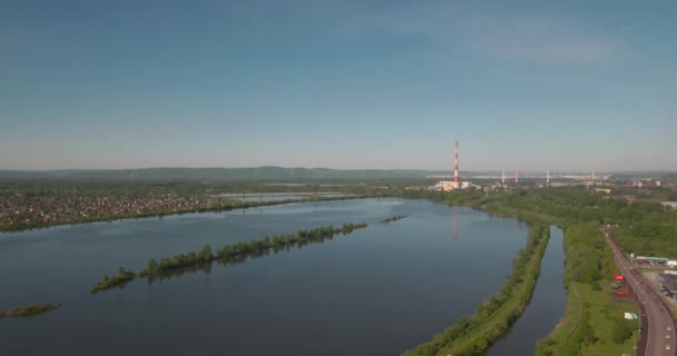 Вид с воздуха на искусственное озеро и завод. Загрязнение воздуха крупным промышленным предприятием на горизонте. 4K — стоковое видео