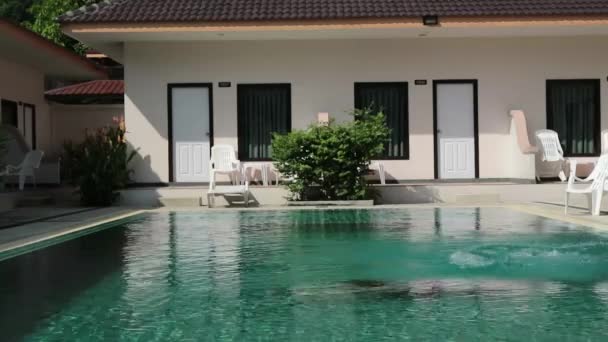 Menina salta em uma piscina. tempo funy em férias de verão — Vídeo de Stock