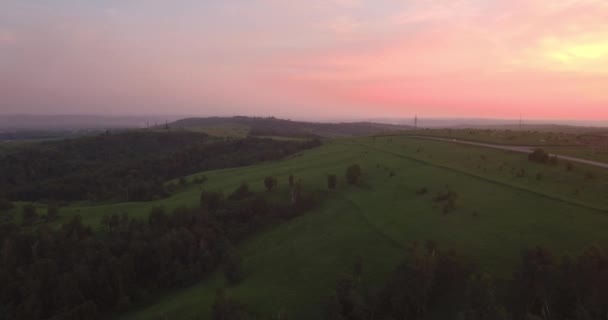 Luchtfoto. lange en bochtige weg door groene heuvels met landschap van het platteland. luchtverontreiniging rond de industriestad. 4k — Stockvideo