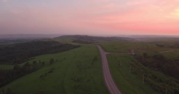 Letecký pohled. dlouhé a klikaté cestě procházející zelené kopce s krajinu. znečištění ovzduší kolem průmyslového města. 4k — Stock video