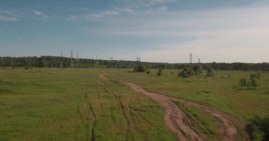 Havadan görünümü. kırsal yol alan ve elektrik yüksek gerilim destekler arasında. yeşil alan arasındaki kırsal yol. 4k