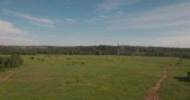 Havadan görünümü. kırsal yol alan ve elektrik yüksek gerilim destekler arasında. yeşil alan arasındaki kırsal yol. 4k