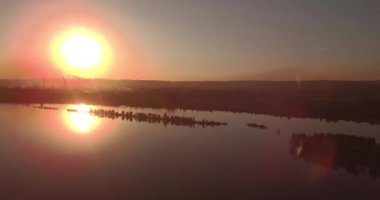 Havadan görünümü. gün batımı göl kıyısında bir küçük şehir ile yukarıda. Endüstriyel Tesis bir ufuk üzerinde. 4k