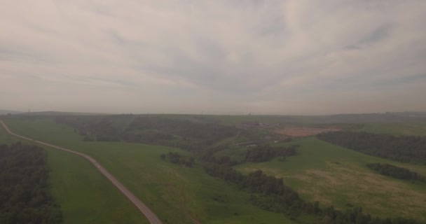 Luftaufnahme. Landstraße zwischen Feldern, Landstraße zwischen grünem Feld und Smog. Luftverschmutzung rund um die Industriestadt. 4k — Stockvideo