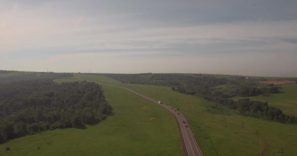 Luchtfoto. landelijke weg tussen velden, weg van het platteland tussen de groene weide met smog. luchtverontreiniging rond de industriestad. 4k — Stockvideo