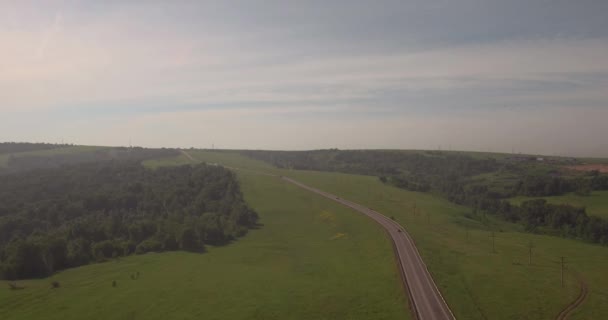 Flybilde. landevei mellom åkrer, landevei mellom grøntmark med smog. luftforurensning rundt industribyen. 4K – stockvideo