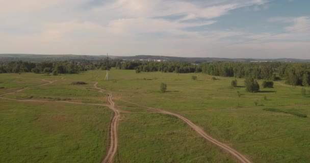 Vue aérienne. route rurale entre les champs et les supports électriques haute tension. route de campagne entre champ vert. 4K — Video