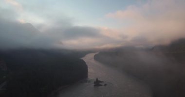 Havadan görünümü. Dağ nehir üzerinden doğar ve sis yüzer. 4k