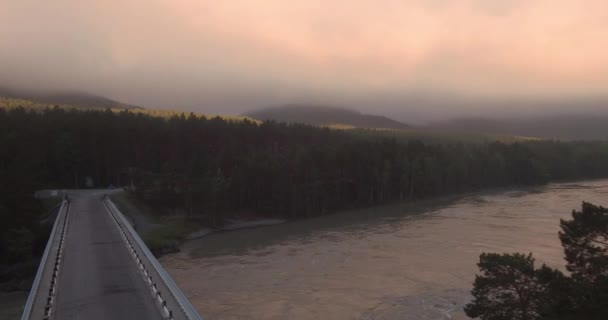 Luchtfoto. brug over de rivier berg waarover is geboren en drijft mist. 4k — Stockvideo