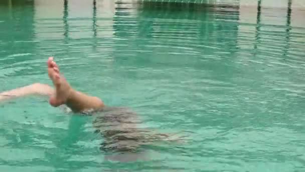 Mädchen spielt mit Wasser in einem Hotelpool. Kinder haben Spaß im Wasser im Freien — Stockvideo