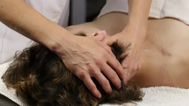 Femme recevant un massage de la tête au centre spa. femme médecin faisant massage du visage. 4K — Video