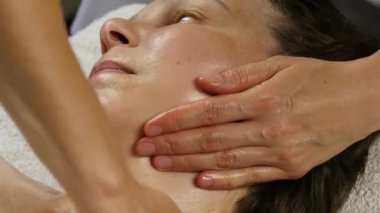 kadın doktor istemciye anti-aging masaj yapıyor. kadın plastik yüz masaj spa saton sahiptir. 4k