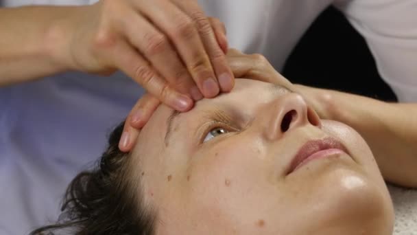 Пластиковий масаж обличчя в спа-сателіті. жінка користується послугами професійного масажиста. 4-кілометровий — стокове відео