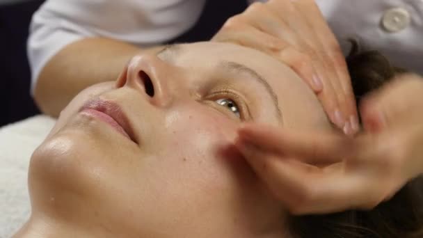 Пластиковый массаж лица в спа-сатоне. женщина пользуется услугами профессионального массажиста. 4K — стоковое видео