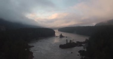 Havadan görünümü. Dağ nehir üzerinden doğar ve sis yüzer. 4k