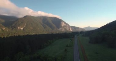 Karayolu dağ manzarası ile hava görünümünü. sabah sis Nehri Vadisi ve dağlar üzerine. 4k