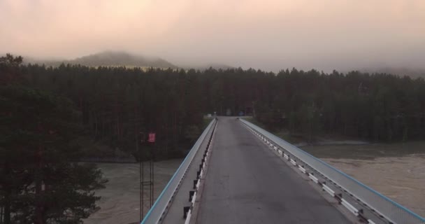 Luchtfoto. brug over de rivier berg waarover is geboren en drijft mist. 4k — Stockvideo