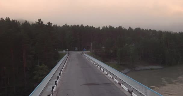 Vista aérea. puente sobre el río de montaña sobre el que nace y flota la niebla. 4K — Vídeos de Stock