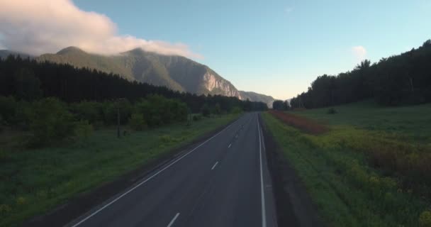 公路与山地景观的鸟瞰图。晨雾笼罩着群山。4k — 图库视频影像