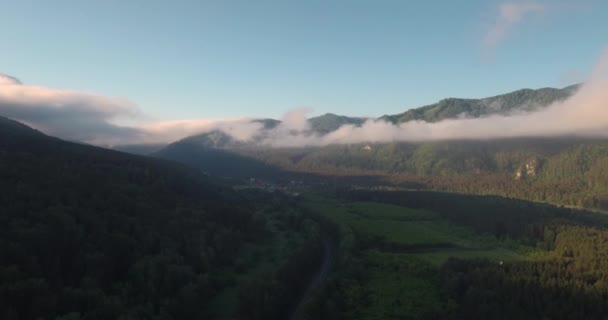 Вид з повітря на шосе з гірським пейзажем. ранковий туман над горами і річкою в долині. 4-кілометровий — стокове відео