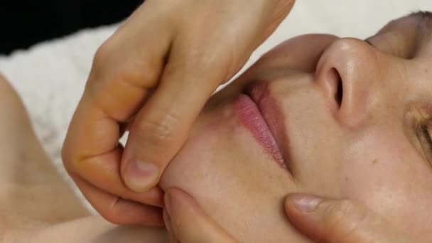 Plast ansiktsmassage i spa saton. kvinnan har tjänster av en professionell massageterapeut. 4k — Stockvideo