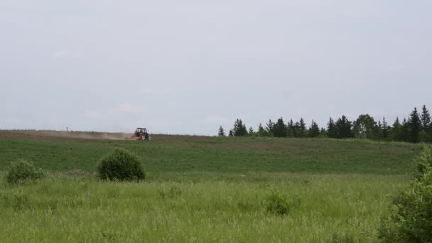 El tractor araña el campo. maquinaria agrícola en un horizonte — Vídeo de stock