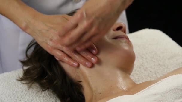 Médico feminino fazendo massagem anti-envelhecimento ao cliente. mulher gosta de massagem facial de plástico em saton spa. 4K — Vídeo de Stock