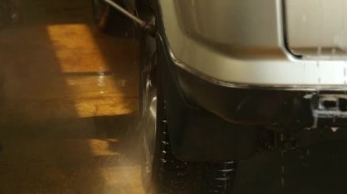 Oto yıkama çalışan bir araba yıkama hizmetinde bir su jeti yıkama kullanır. ağır çekim