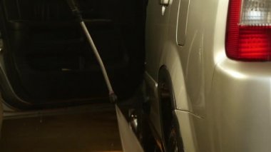 Adam bir oto yıkama hizmetinde bir araba yıkama. Araba su jeti yıkama ile temizledim. ağır çekim