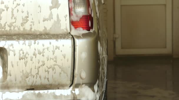 Spuma picură din maşină. Curățarea unei mașini într-un serviciu de spălătorie auto. mișcare lentă — Videoclip de stoc