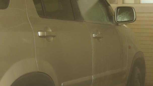 Mann wäscht Auto in einer Waschanlage Auto mit Wasserstrahl gereinigt. Zeitlupe — Stockvideo