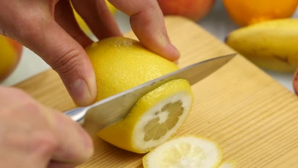 Mulher corta os citrinos em uma tábua de corte de madeira com variedade de frutas ao redor. Perda de peso e conceito de dieta. câmara lenta — Vídeo de Stock