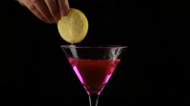 kadının elinde pembe bir kokteyl limon bir karanlıkta hazırlar. parti kavramı. ağır çekim