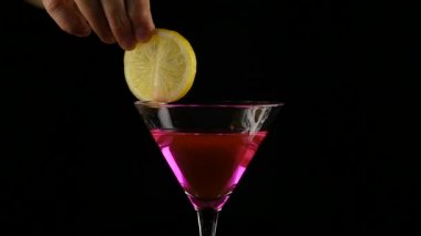 kadının elinde pembe bir kokteyl limon bir karanlıkta hazırlar. parti kavramı. ağır çekim