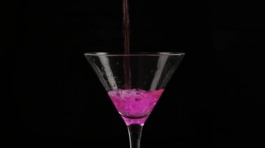 Pembe Kokteyl koyu arka planda bir glasson dökülür. 4k