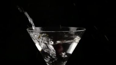 kiraz bir bardak alkol karanlık bir arka plan üzerinde kokteyl ile içine atılmış. bir kokteyl ve parti kavram hazırlar. ağır çekim