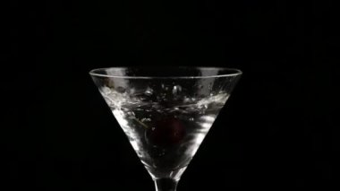 kiraz bir bardak alkol karanlık bir arka plan üzerinde kokteyl ile içine atılmış. bir kokteyl ve parti kavram hazırlar. ağır çekim