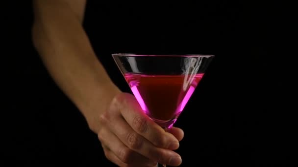 女人的手准备一个粉红色的鸡尾酒与柠檬在黑暗中。党的理念。慢动作 — 图库视频影像