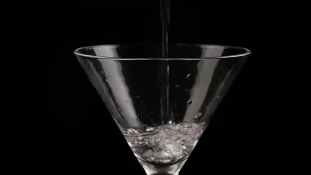 Alcool versato in un bicchiere su uno sfondo scuro. prepara un cocktail e un concetto di festa. rallentatore — Video Stock