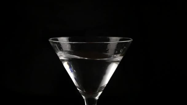 Cereja lançada em um copo com coquetel de álcool em um fundo escuro. prepara um coquetel e conceito de festa. câmara lenta — Vídeo de Stock