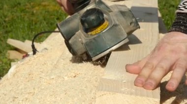 planya makinesi bir ahşap üzerine çalışan adam. Planer farklı taraftan cips sinek