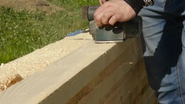 Los trabajadores del taller utilizan la máquina de cepillado de madera. Las virutas vuelan en diferentes lados de la cepilladora — Vídeos de Stock